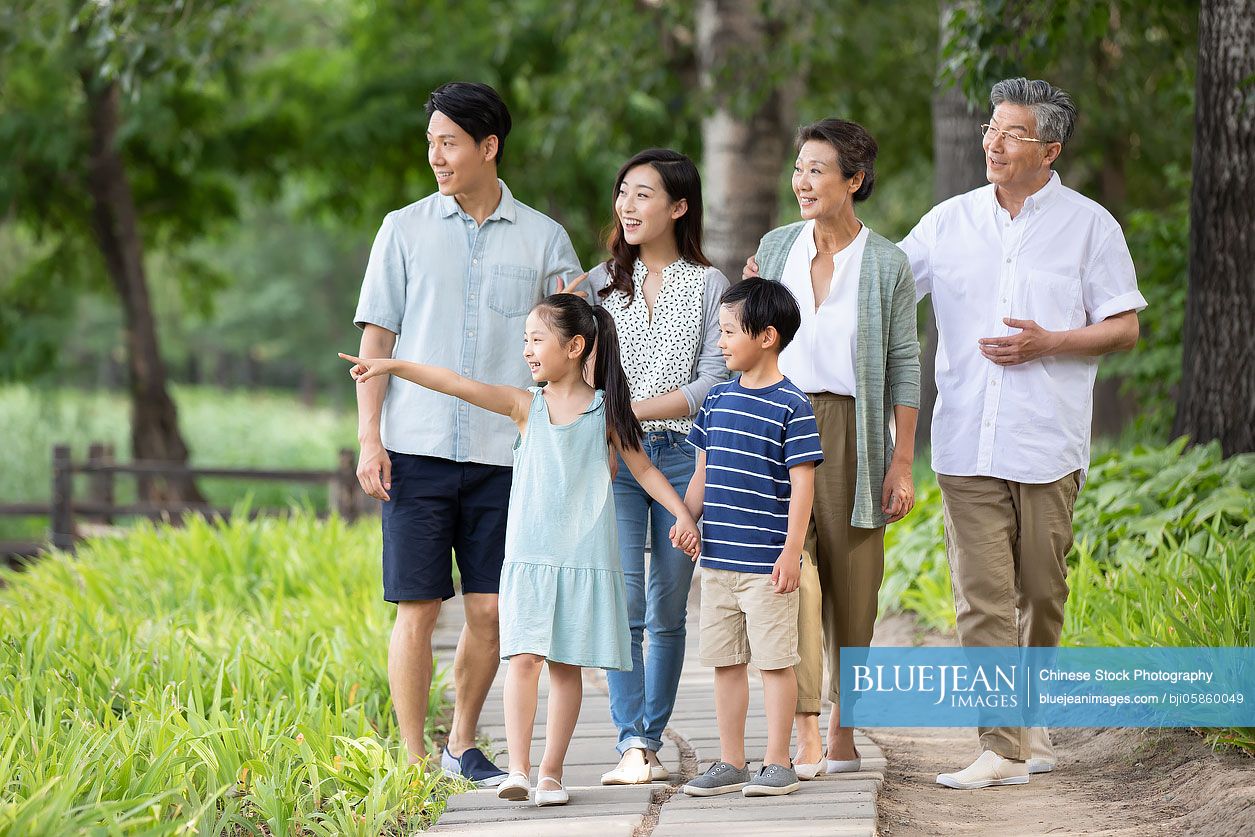 Happy Chinese family walking in park