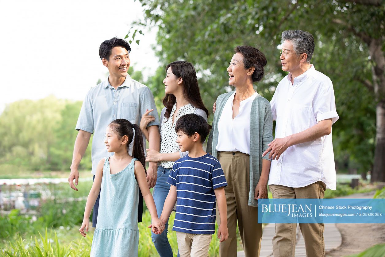 Happy Chinese family walking in park