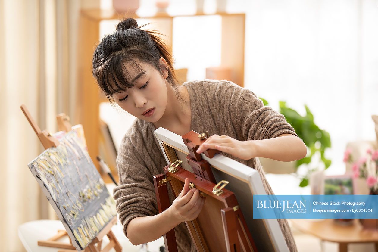 Young Chinese woman preparing for painting at home