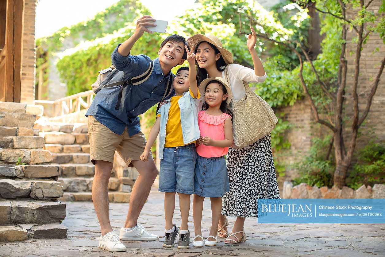 Young Chinese family taking selfie outdoors