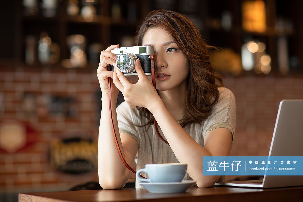 优雅女士在咖啡店使用相机