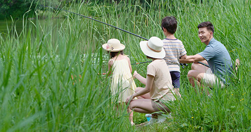 Happy young Chinese family fishing outdoors,4K