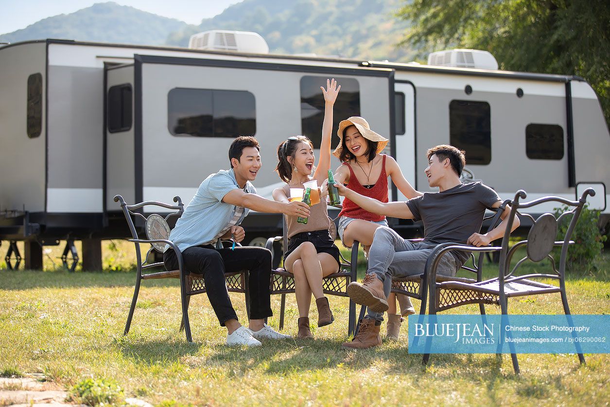Happy young Chinese friends having a picnic outdoors