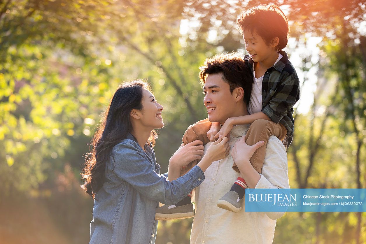 Happy young Chinese family having fun in park