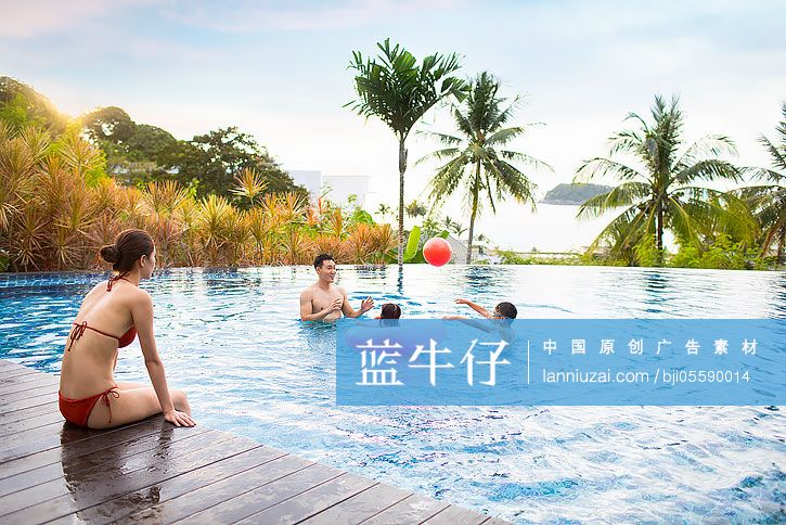 快乐的年轻家庭在泳池里嬉戏