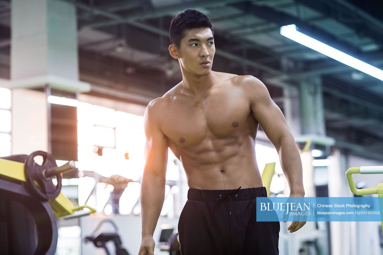 Young Chinese man resting at gym