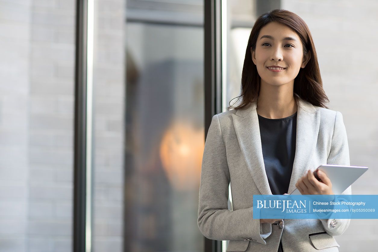 Young Chinese businesswoman holding a digital tablet