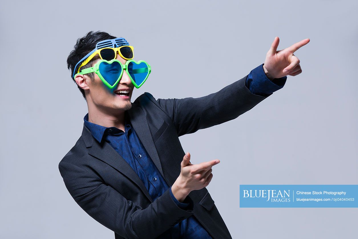 Hip young Chinese man wearing multiple pairs of sunglasses-High-res stock  photo for download