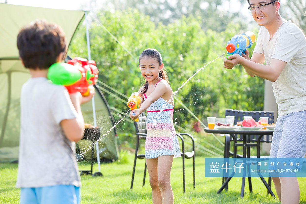 快乐的父亲和孩子玩水枪