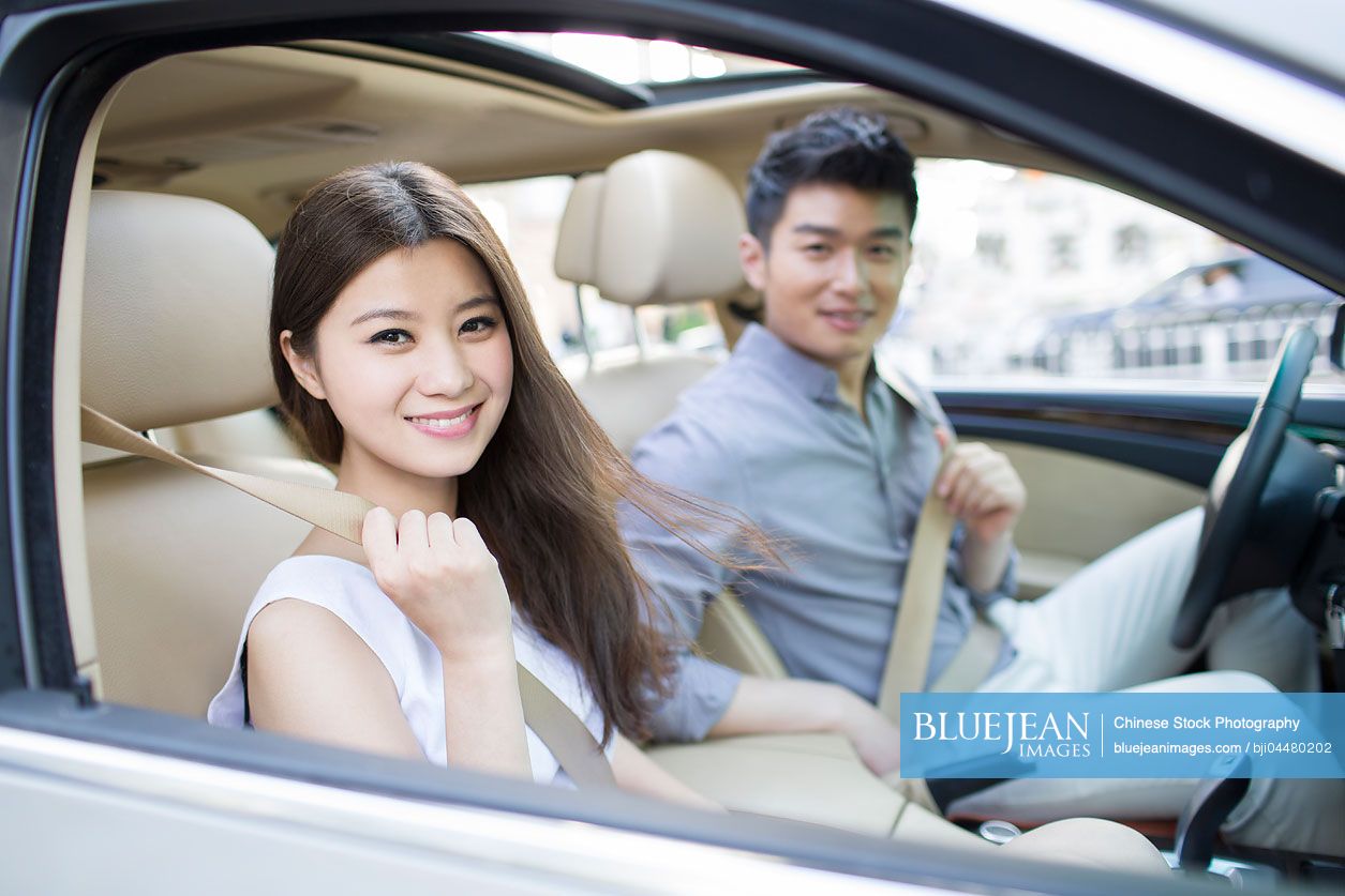 Happy young Chinese couple in a car
