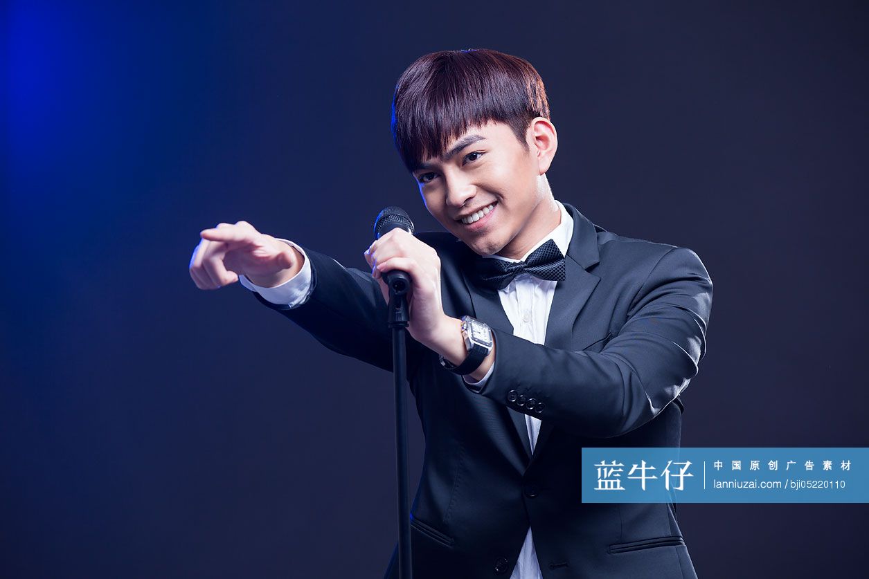 年轻男子拿着麦克风唱歌