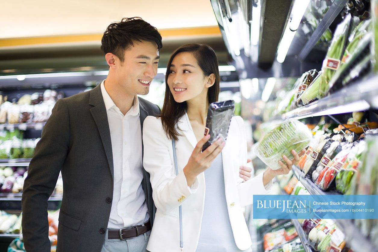 Young Chinese couple shopping in supermarket