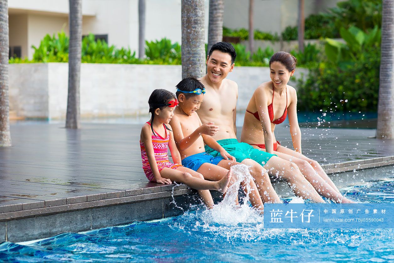 快乐的年轻家庭坐在泳池边戏水