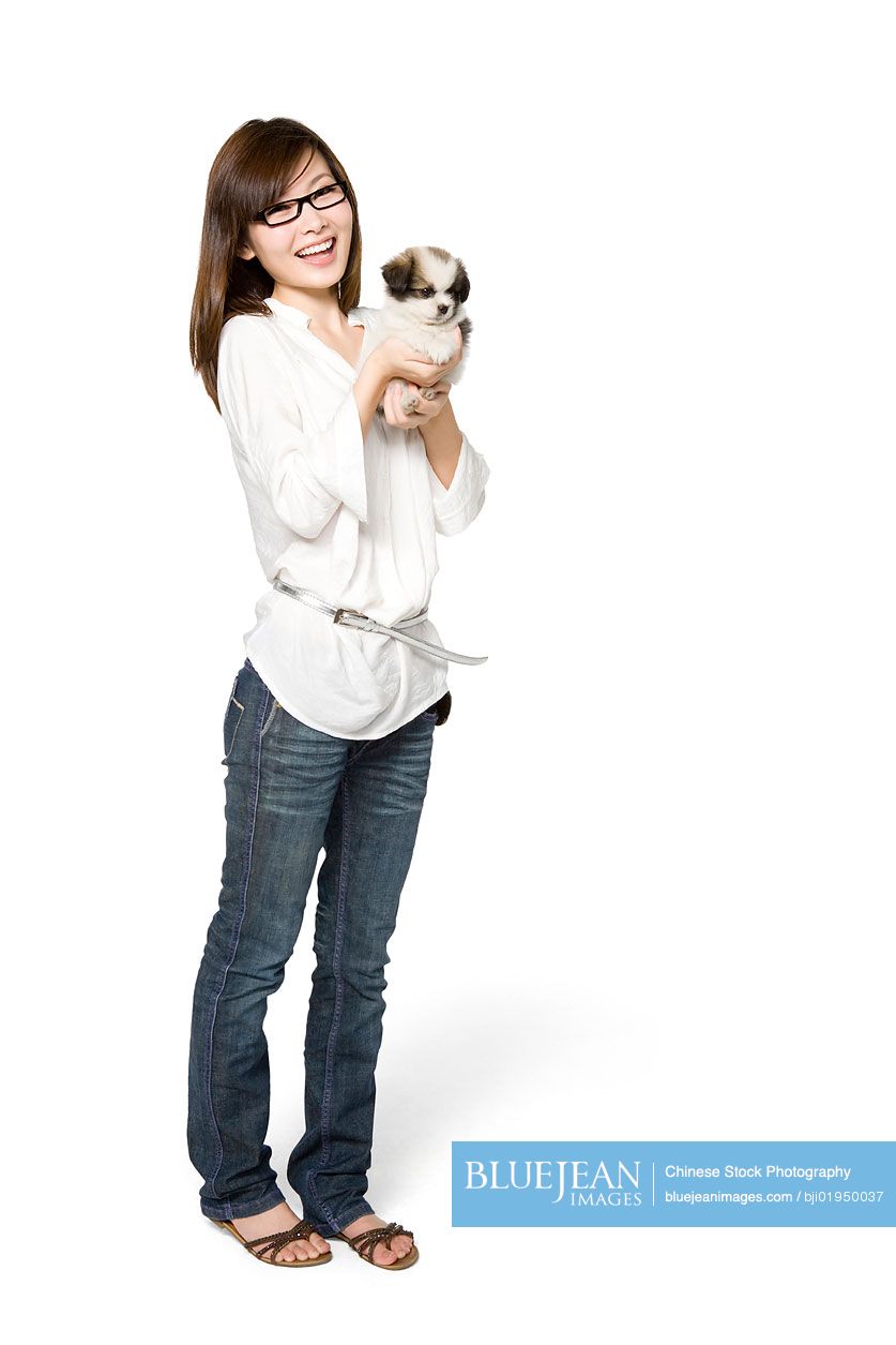 Portrait of young Chinese woman with Shih Tzu puppy