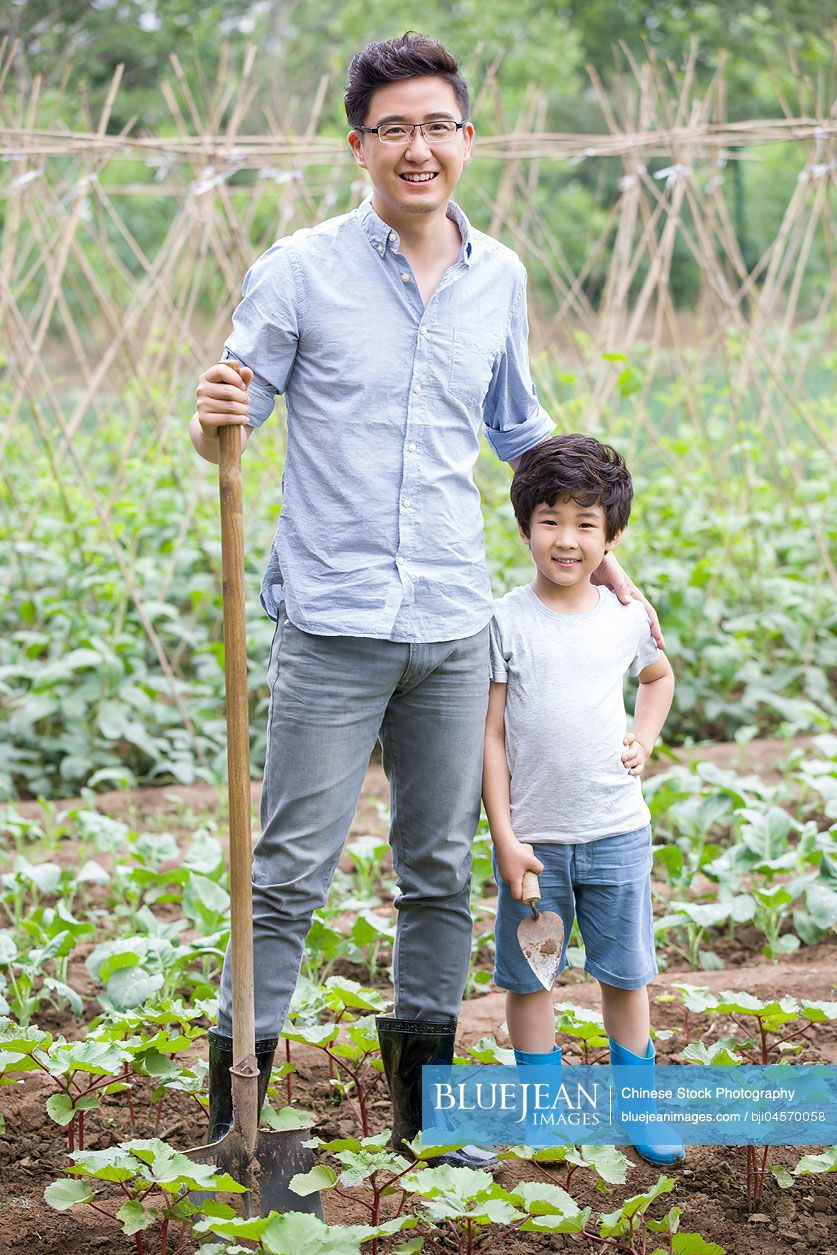 Young Chinese father and son gardening together