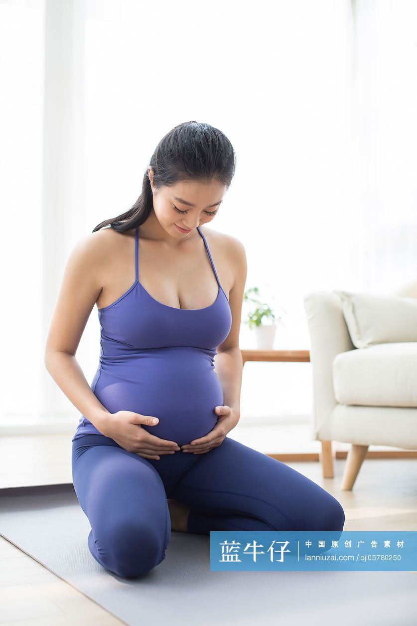 年轻孕妇手放在肚子上