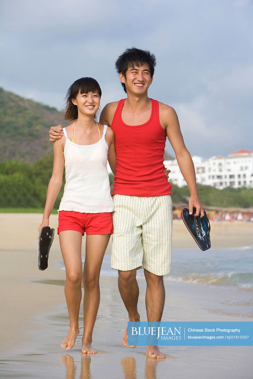 Young Chinese couple on a romantic walk along the beach-High-res stock  photo for download