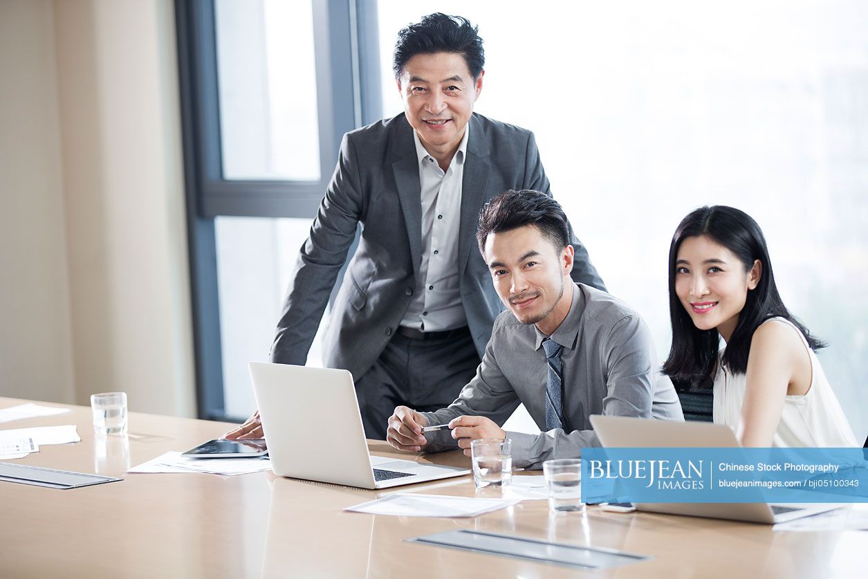 Confident Chinese business people in meeting room