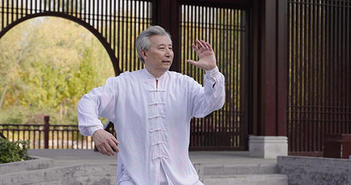 Cheerful senior Chinese man practicing Tai Chi in the park,4K