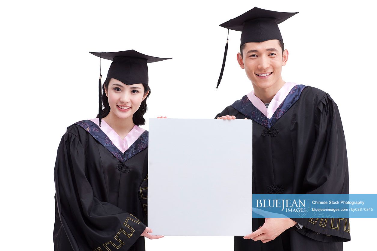 Happy Chinese college graduates with whiteboard