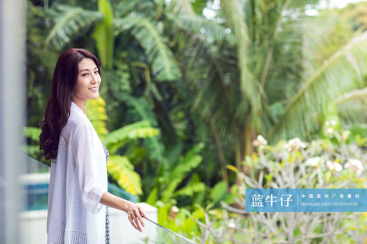 快乐的年轻女子在阳台上看风景