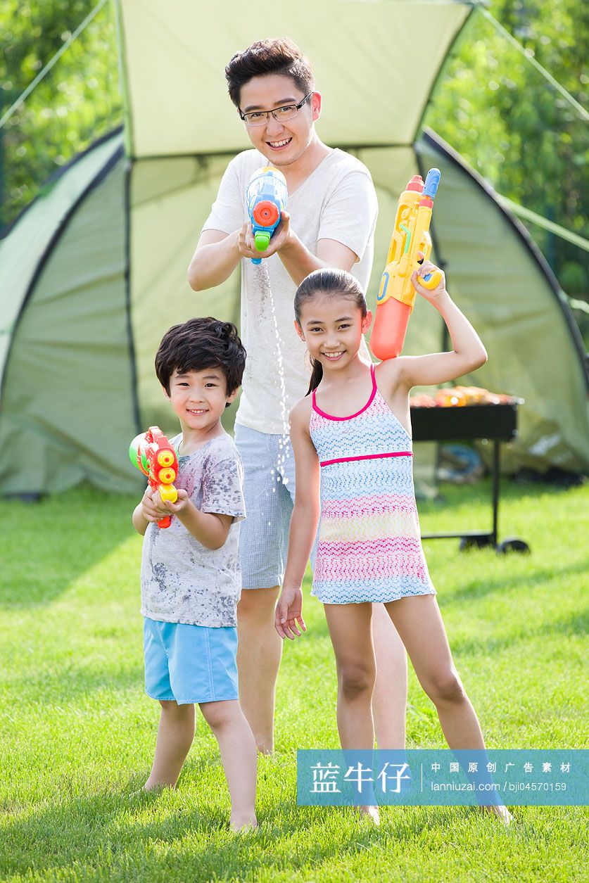 快乐的父亲和孩子玩水枪