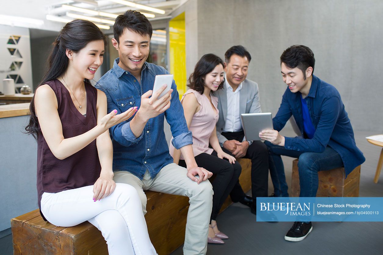 Chinese business people using portable devices in office