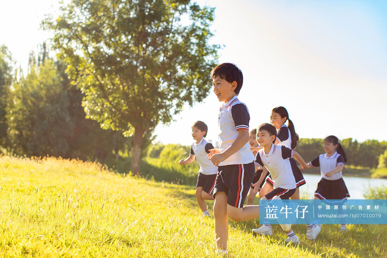 快乐的小学生在草地上奔跑