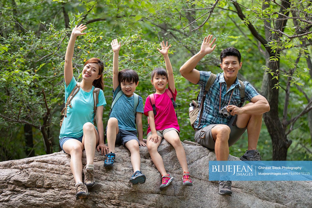 Happy young Chinese family hiking outdoors