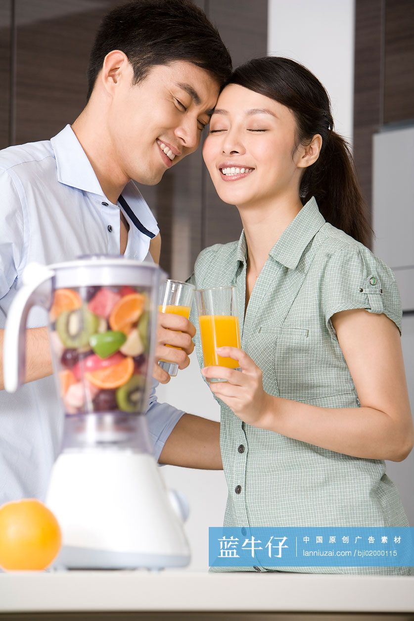 青年夫妇在厨房做鲜榨果汁
