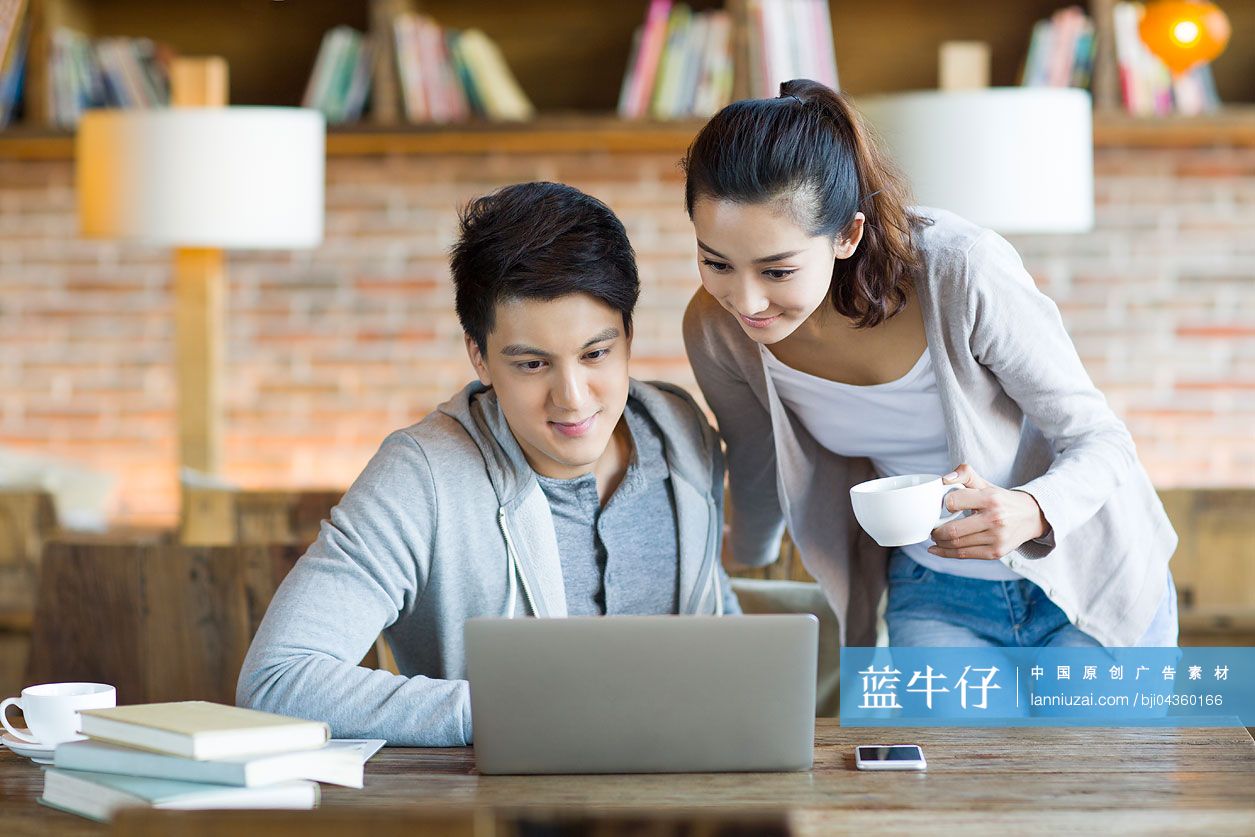 年轻情侣在咖啡馆使用笔记本电脑-蓝牛仔影像-中国原创广告影像素材