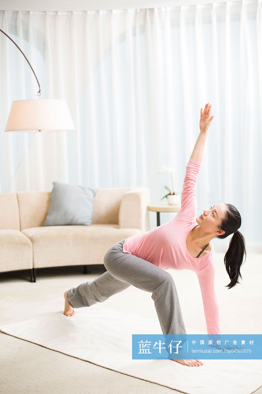 年轻女子在客厅练习瑜伽