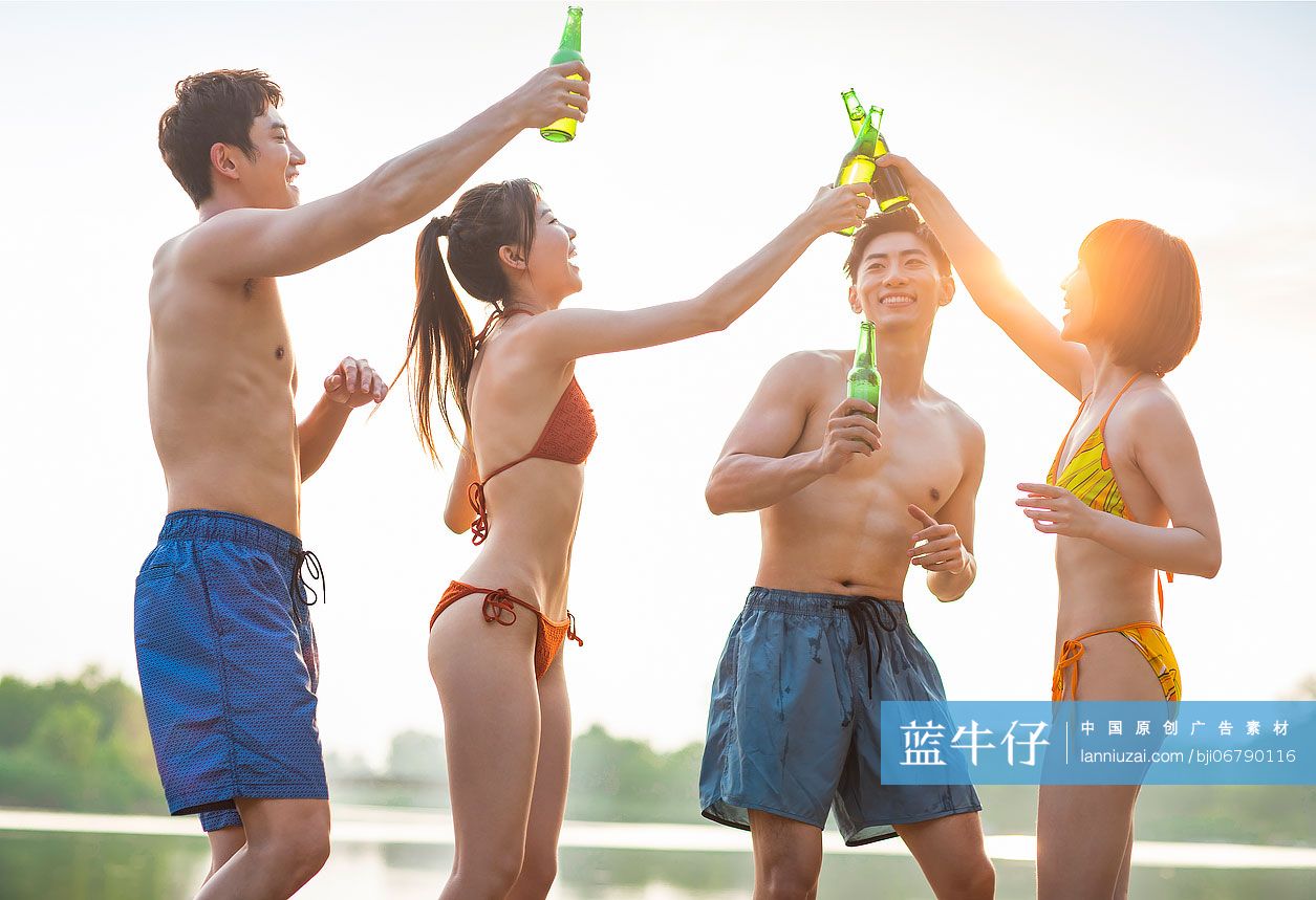 快乐的年轻人在湖边喝啤酒