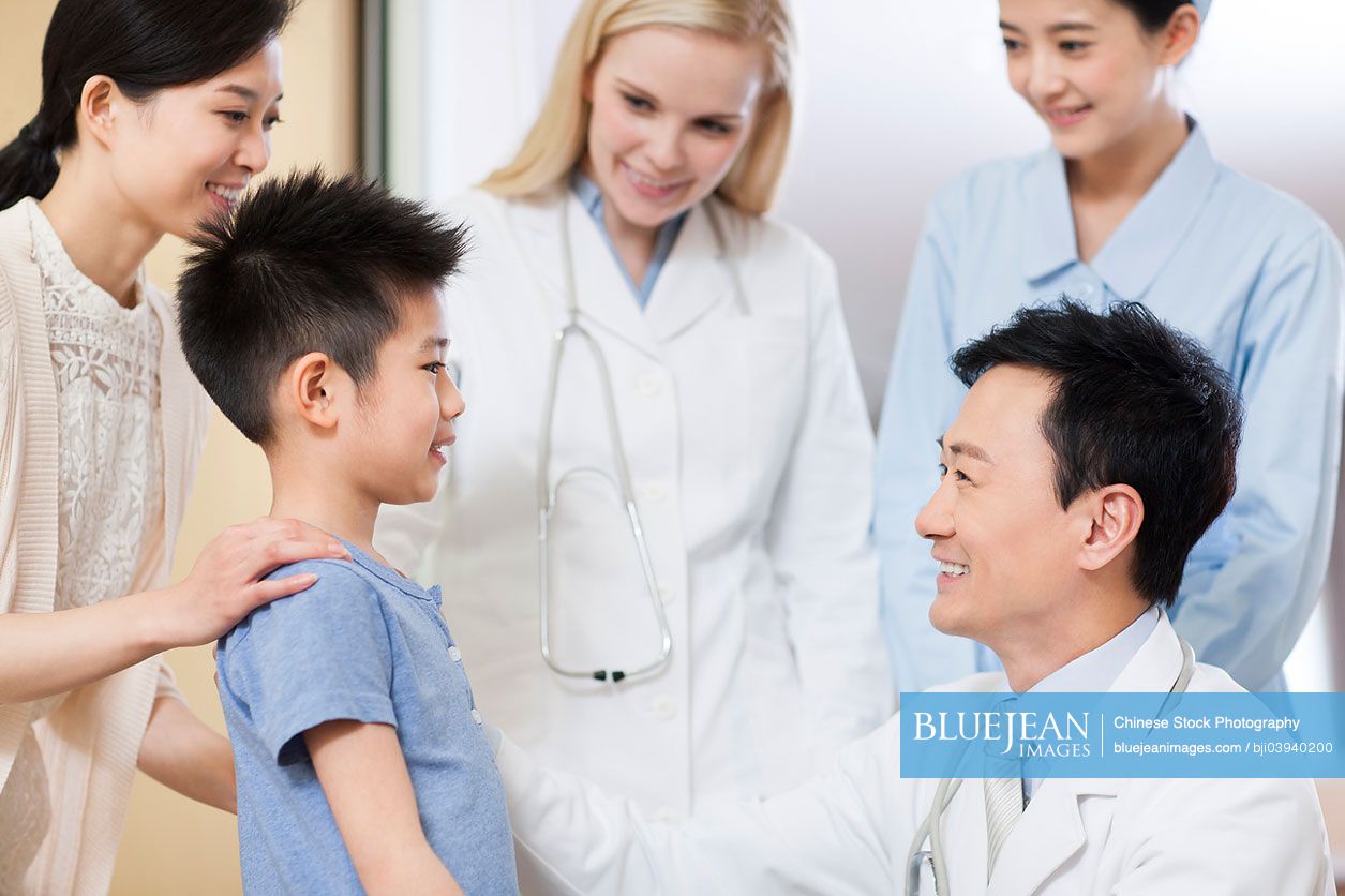 Chinese doctor talking to little boy in hospital