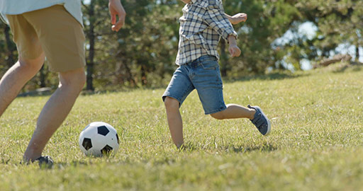 快乐的父子俩在草地上踢足球