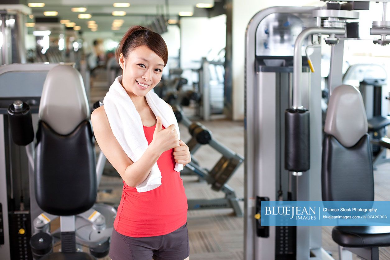 Young Chinese woman happy at gym