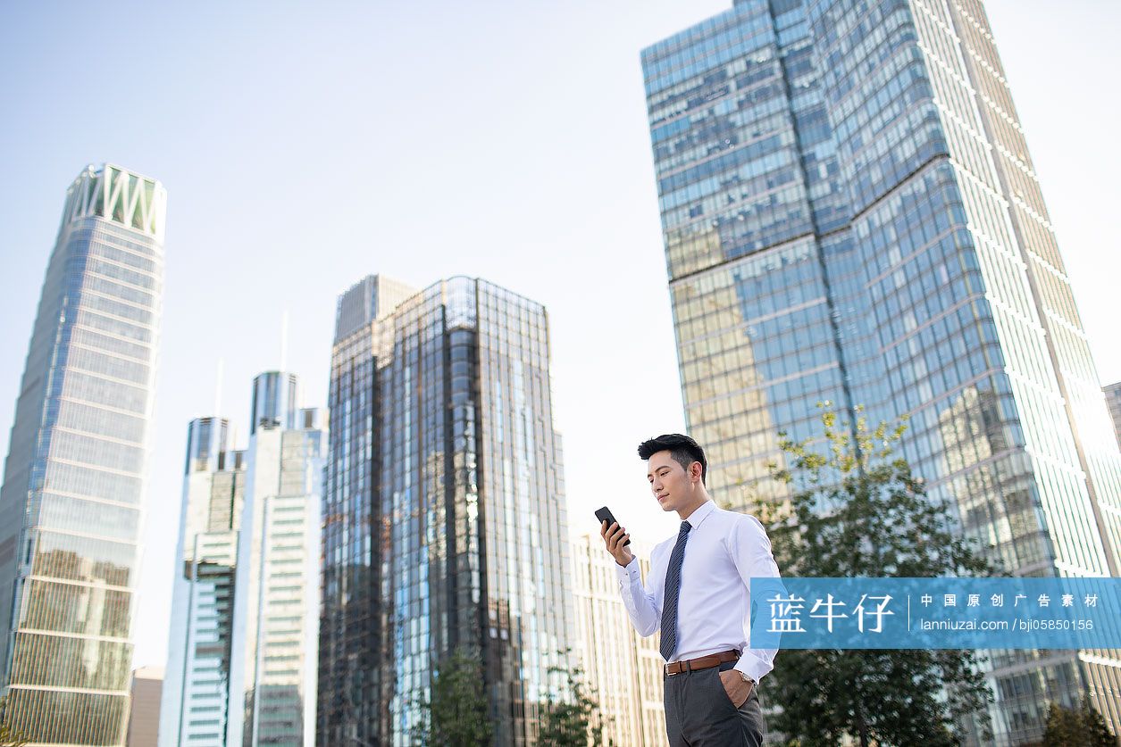 自信的年轻商务男士使用手机