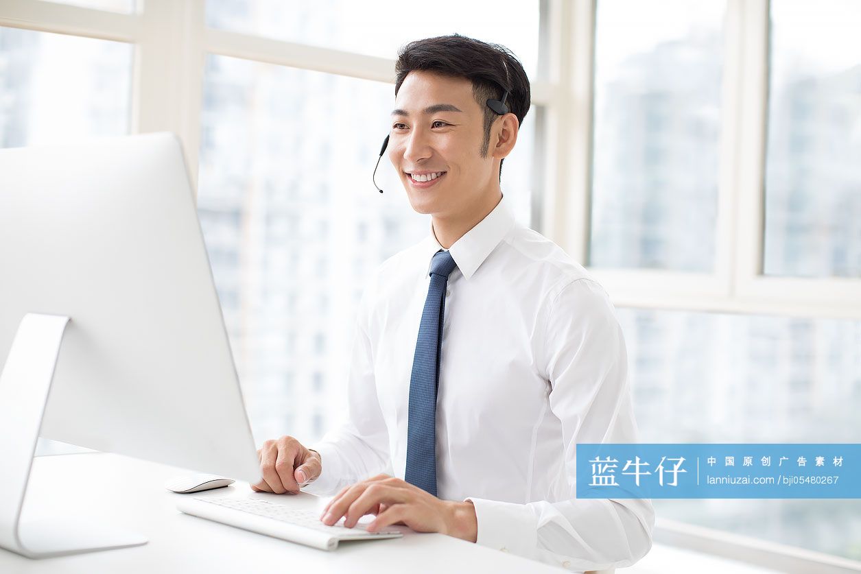 自信的年轻商务男士戴着耳麦工作