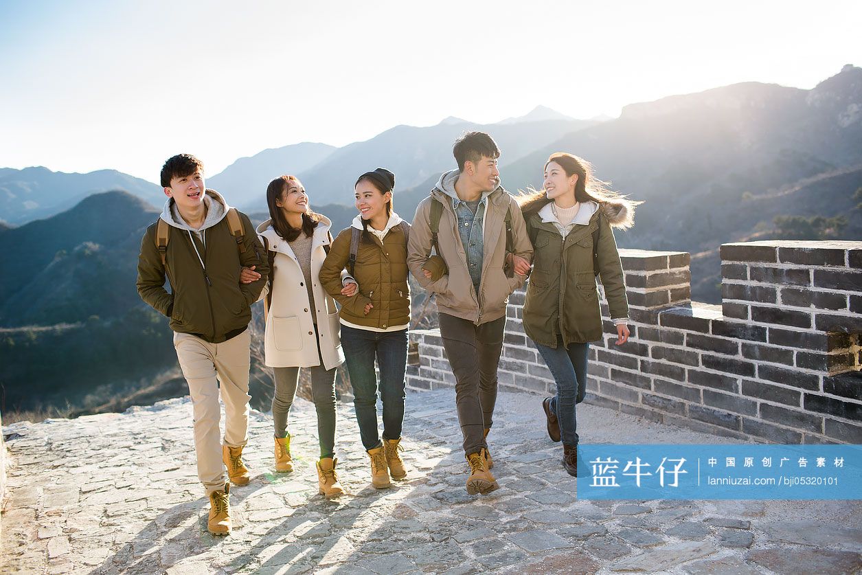 Happy young Chinese friends enjoying winter outing on the Great Wall