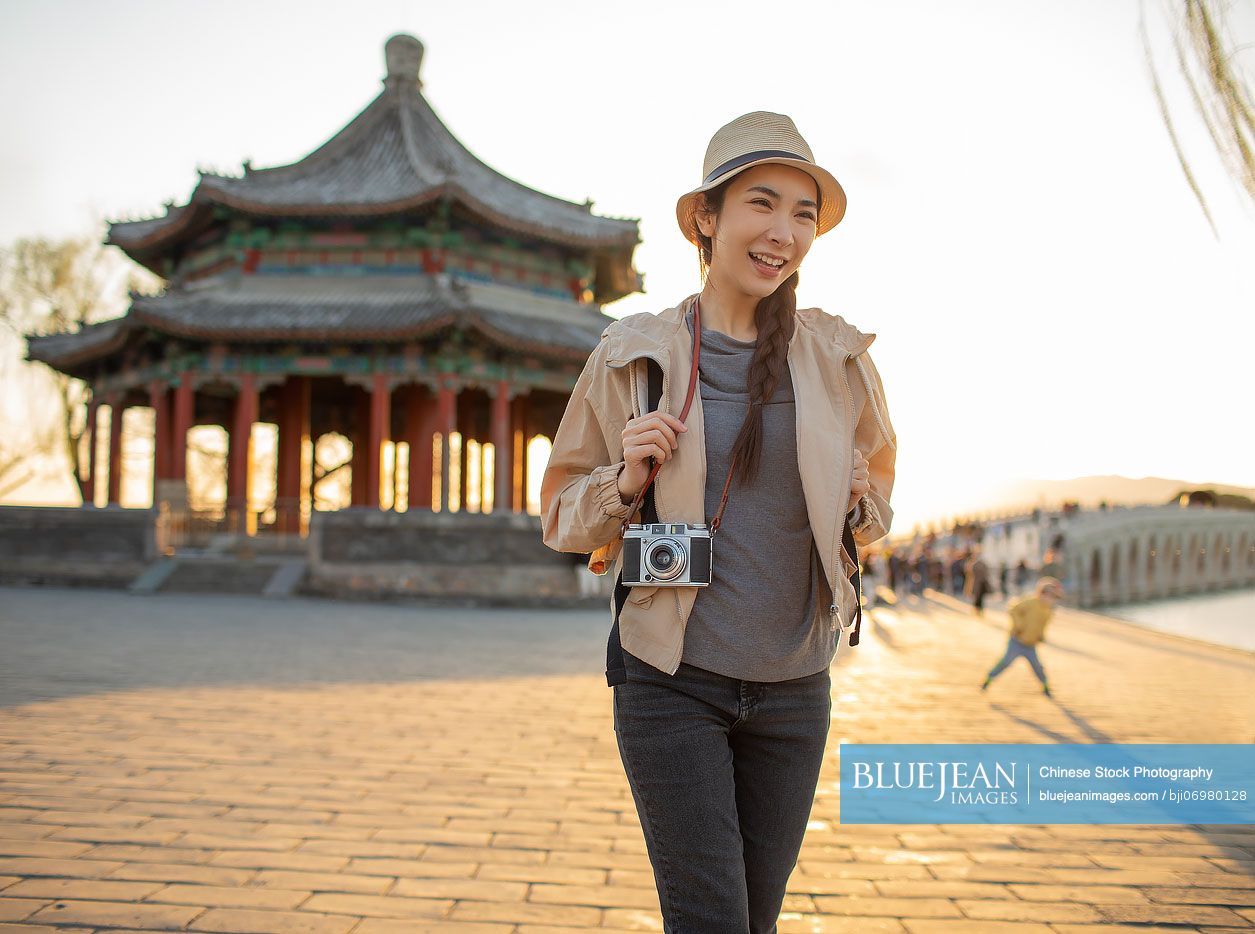 Cheerful young Chinese woman travelling at the Summer Palace