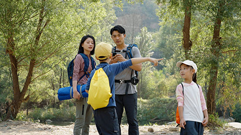 Happy young Chinese family hiking outdoors