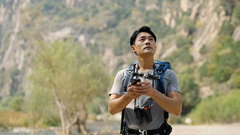 Young Chinese man hiking outdoors