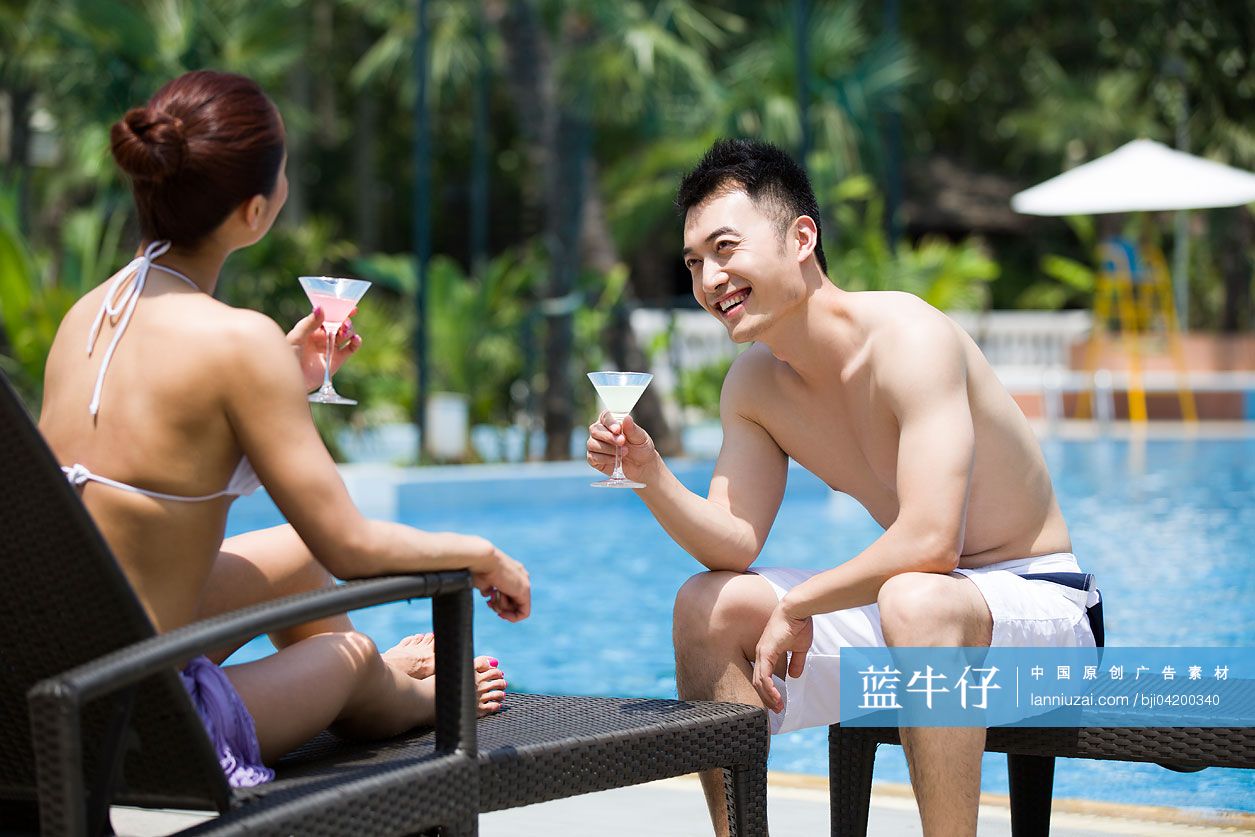 年轻情侣在泳池边聊天