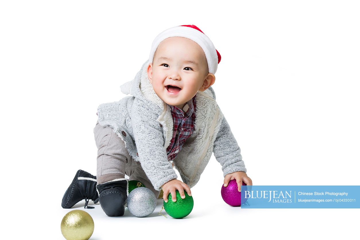 Cute Chinese baby playing with Christmas lights