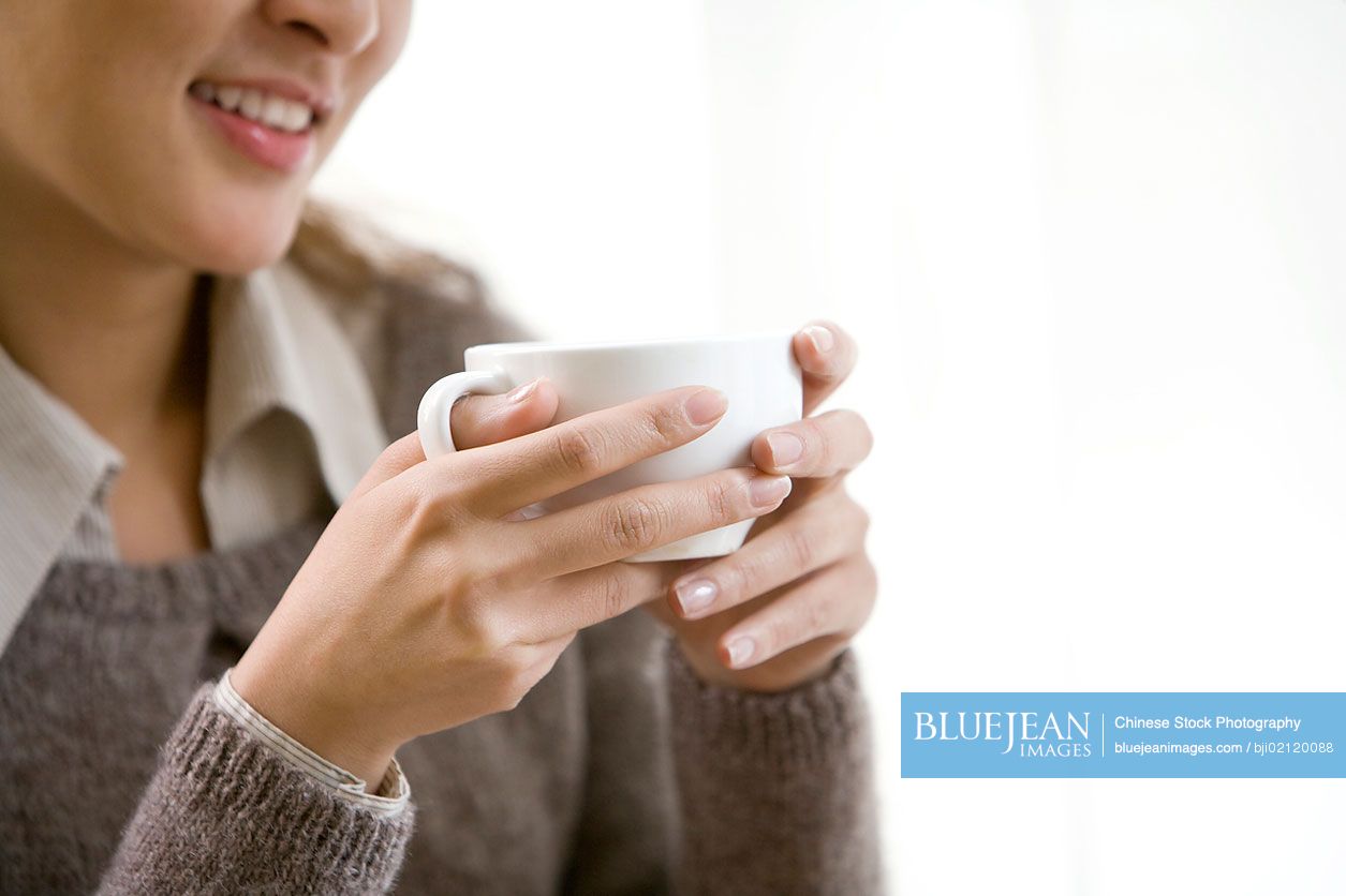 A Chinese woman holding a cup of coffee