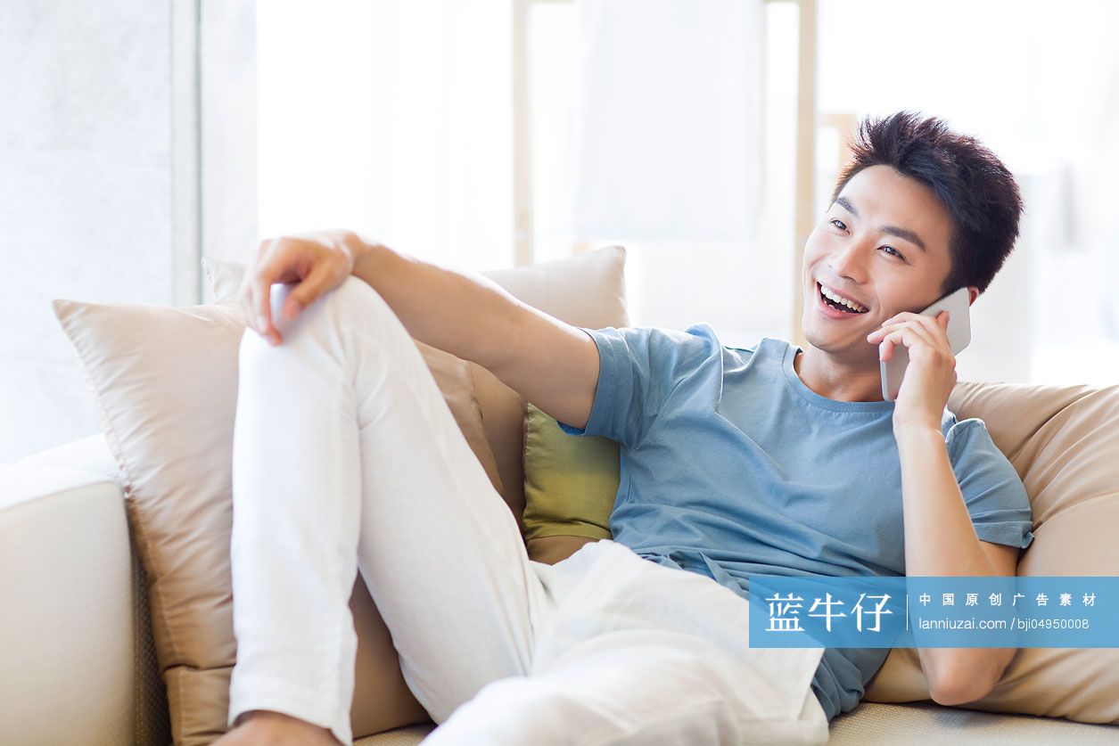 年轻男子在沙发上打电话