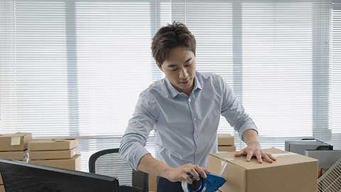 Chinese small business owner packing boxes in office,4K