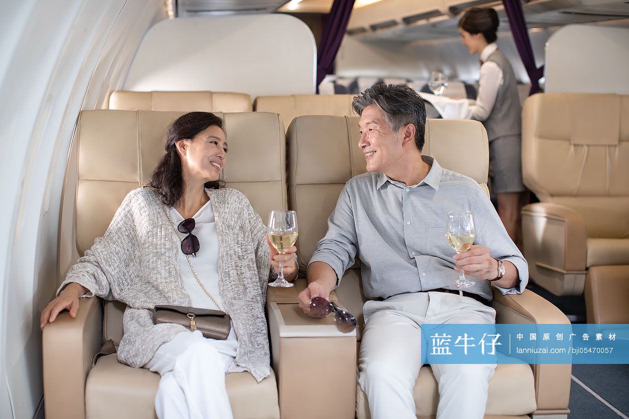中老年夫妇在飞机上喝葡萄酒