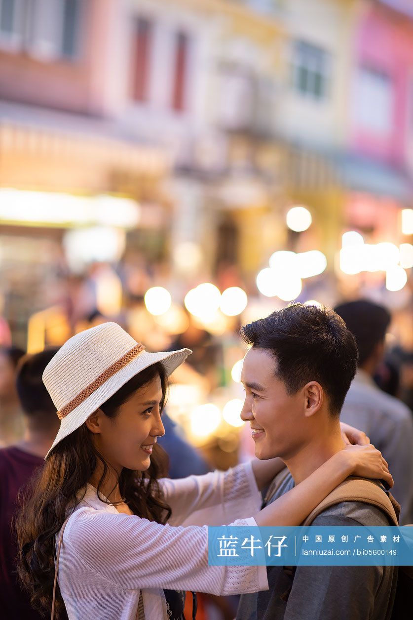 快乐的年轻情侣逛街头集市