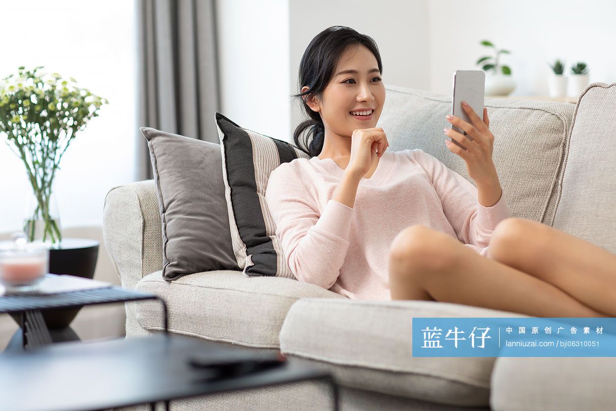 快乐年轻女士在家使用手机